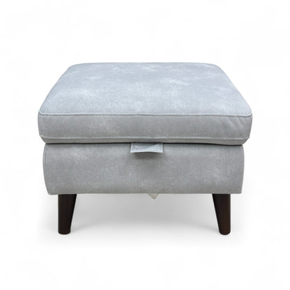 The footstool shown with the lid removed, placed beside the base to display the empty storage area clearly.