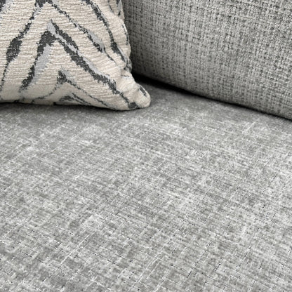 A close-up shot focusing on the seat and back cushions and the woven texture of the silver fabric.