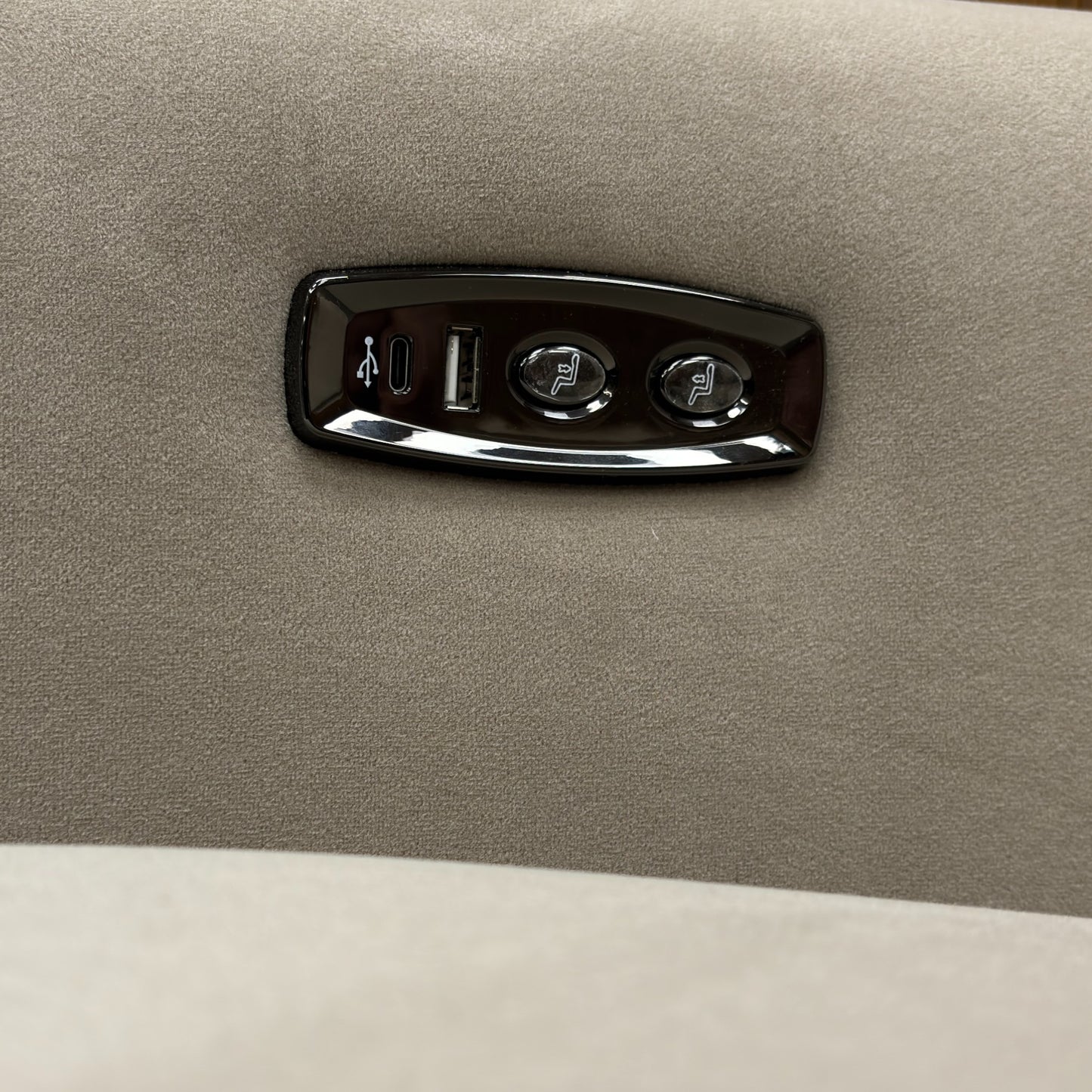 A close-up shot of the armchair's controls, showing the power buttons and the integrated USB charging port.