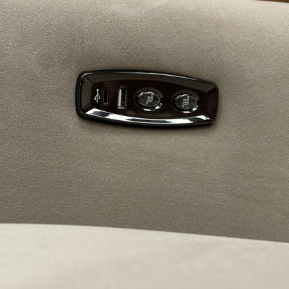 A close-up shot of the armchair's controls, showing the power buttons and the integrated USB charging port.