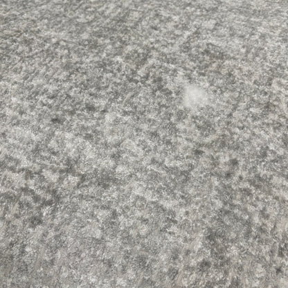 A close-up shot focusing on the armrest, the silver fabric texture, and how the scatter cushions sit on the main sofa.