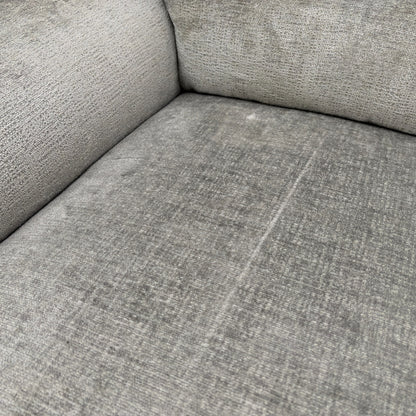 A close-up shot focusing on the texture and color of the dove grey fabric upholstery.