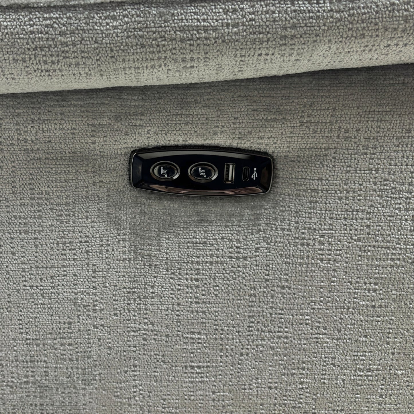 A close-up shot focusing on the armrest, highlighting the power buttons and the integrated USB charging port.