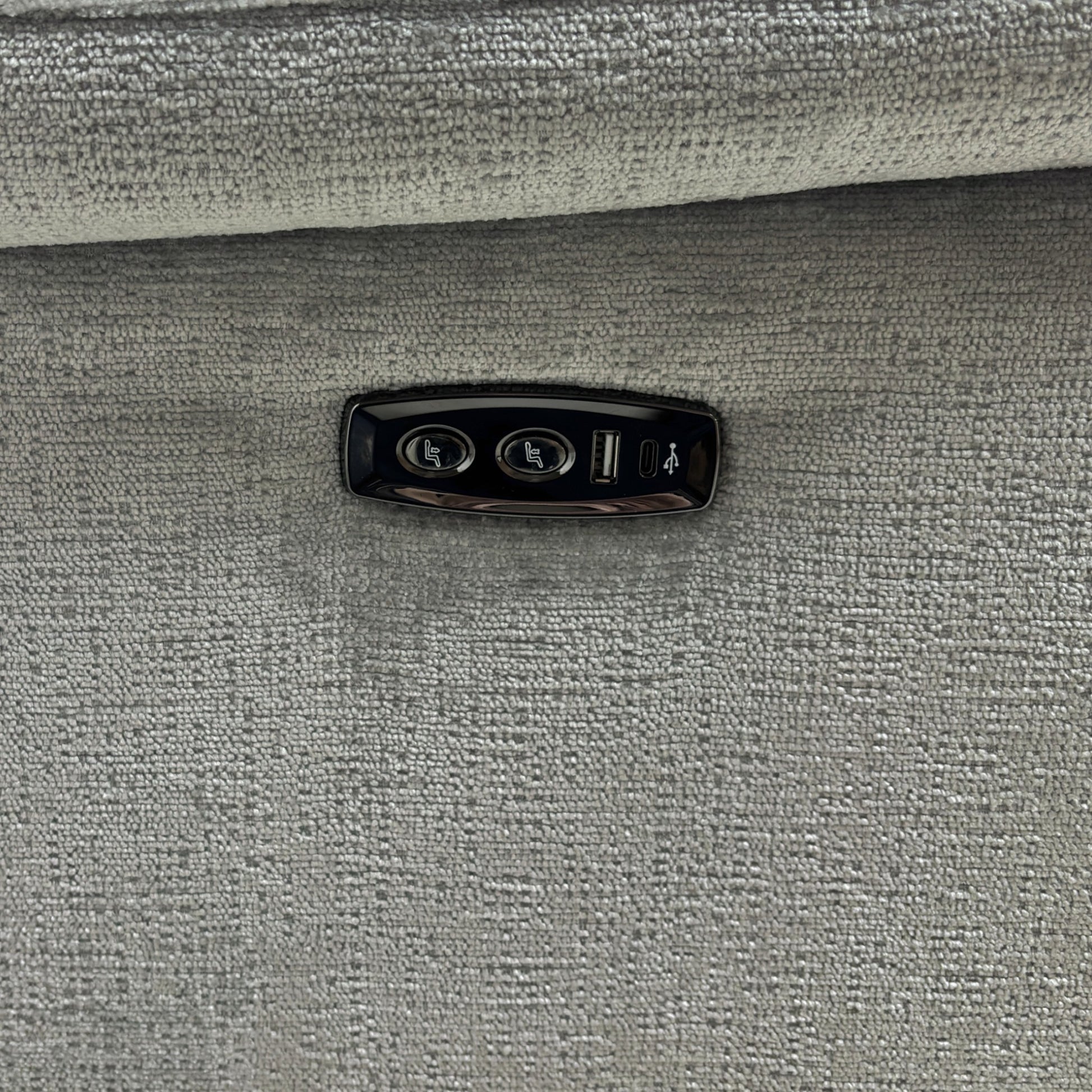 A close-up shot focusing on the armrest, highlighting the power buttons and the integrated USB charging port.