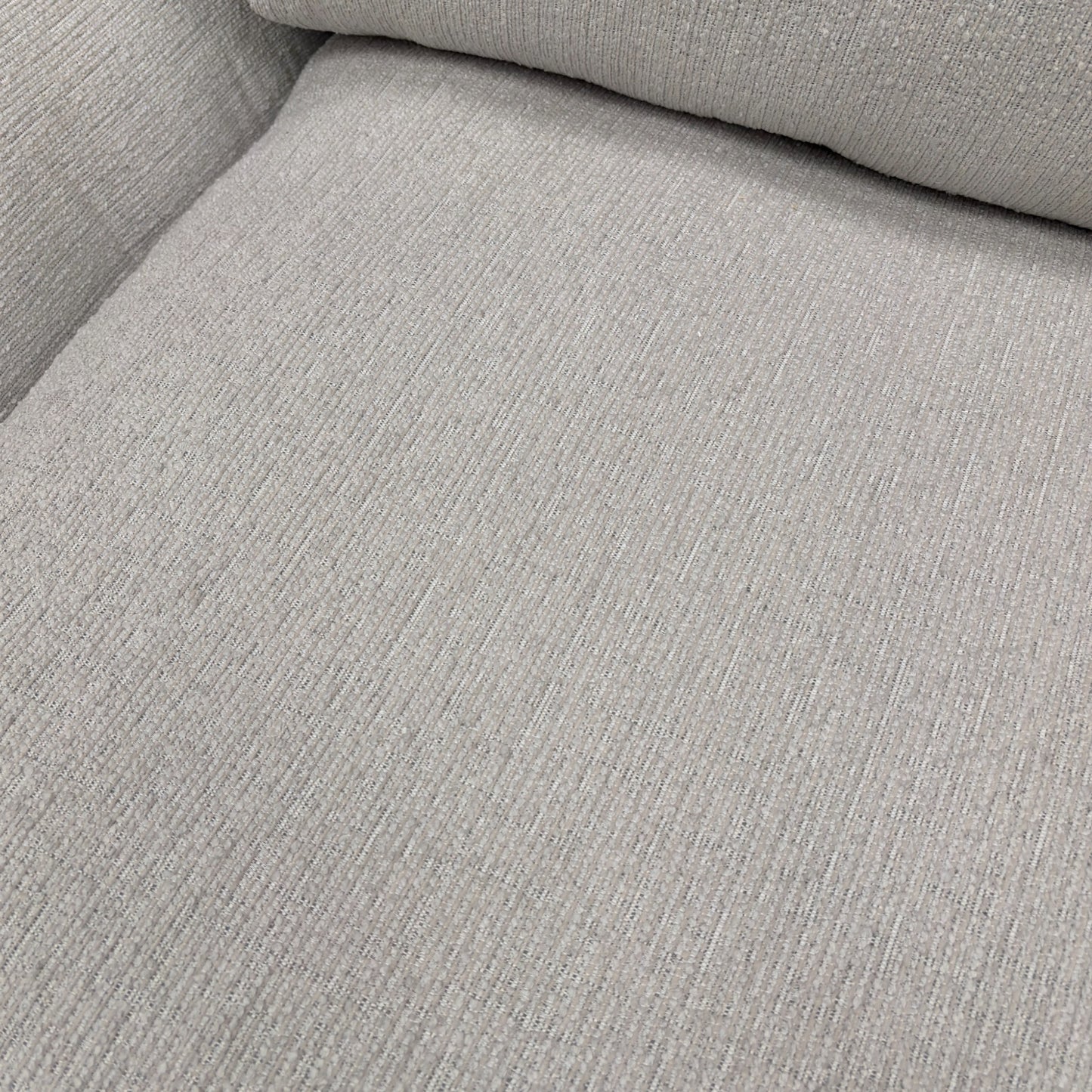 A close-up shot focusing on the armrest and the texture of the ivory chord fabric.
