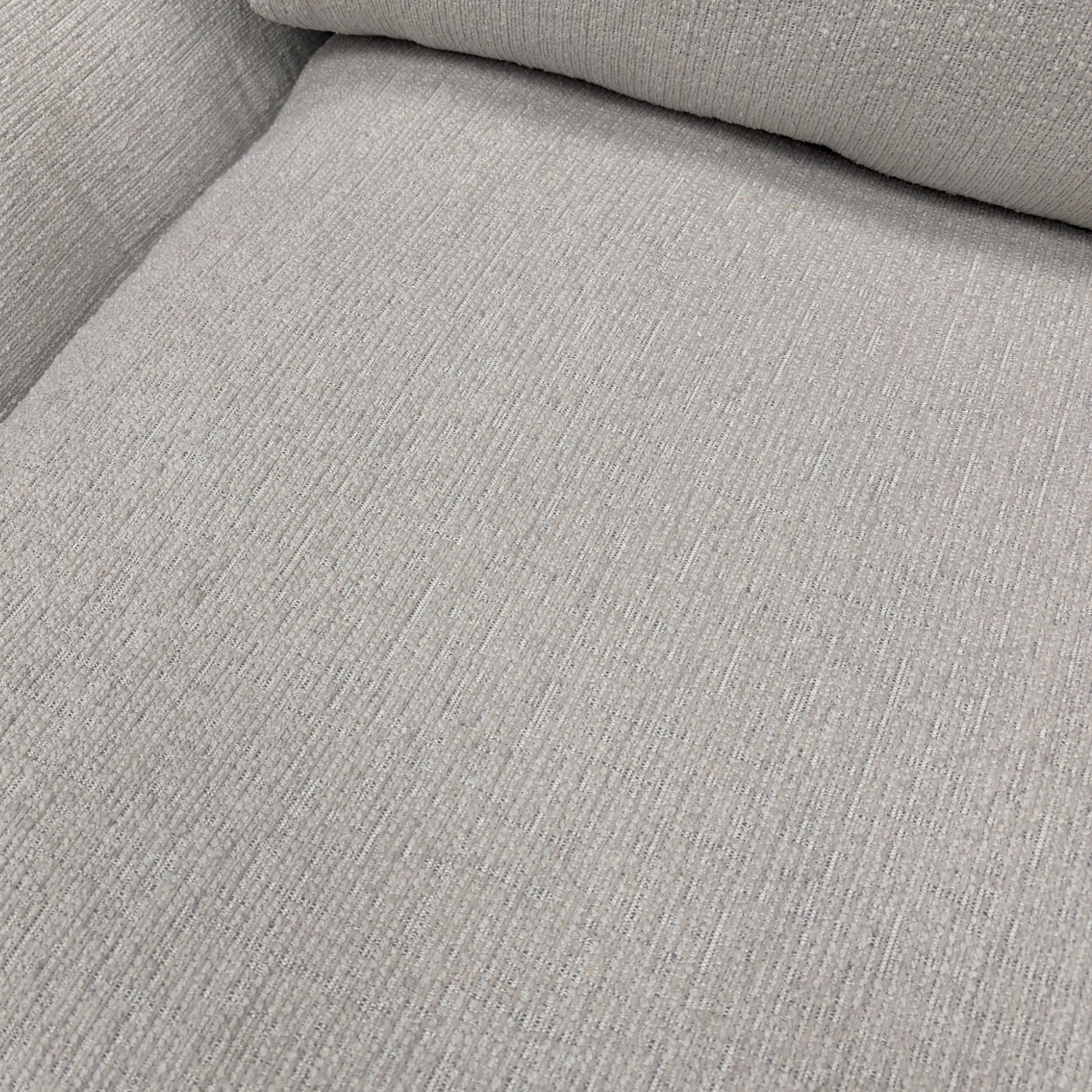 A close-up shot focusing on the armrest and the texture of the ivory chord fabric.