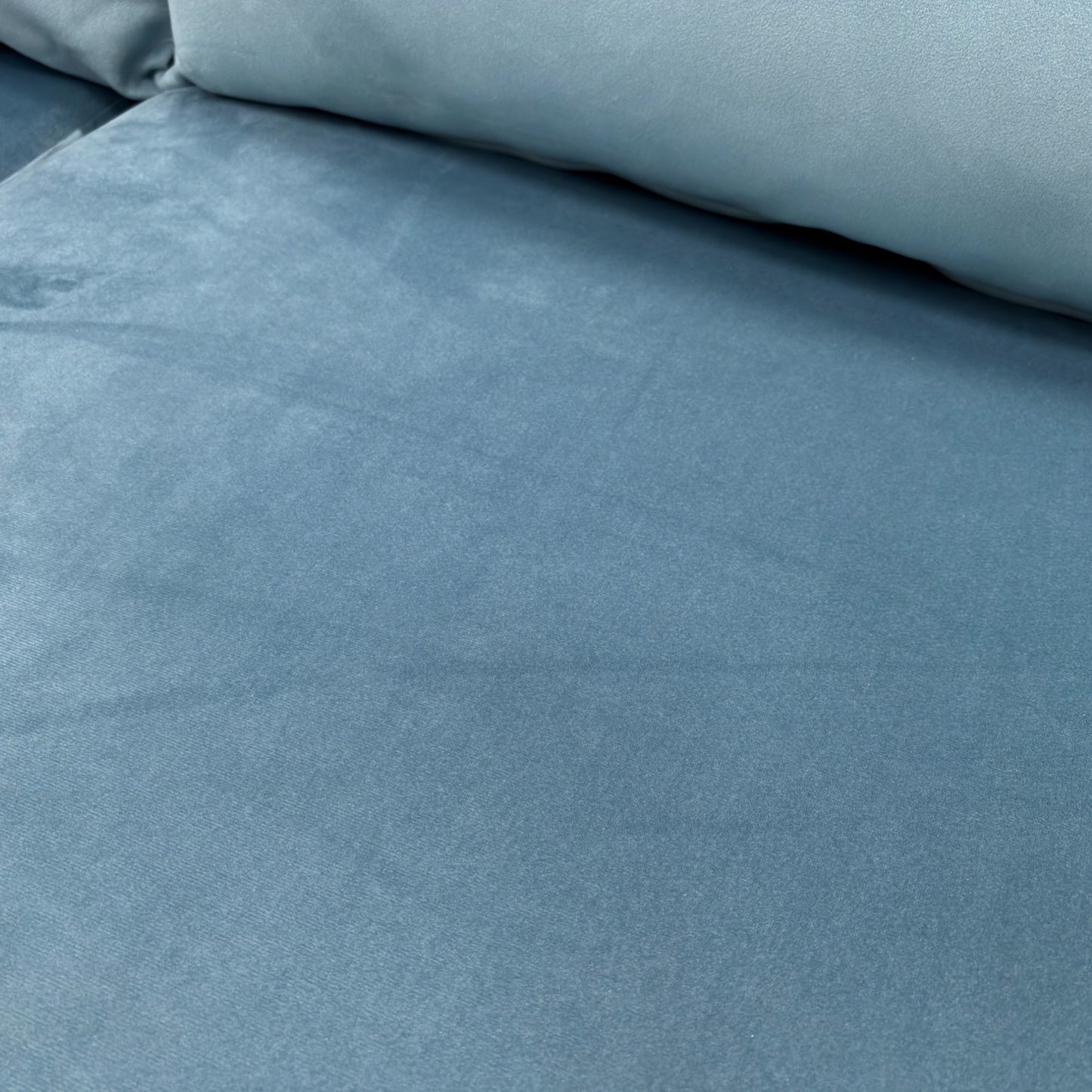 A close-up shot focusing on the Sky Velvet fabric and the button detailing on the back cushions.