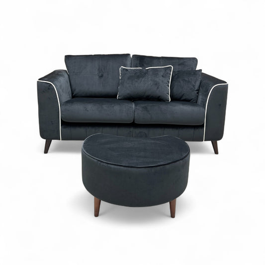 Full front-angled view of the Remi 2 Seater Sofa and its matching Half Moon Footstool in black velvet, showcasing the set together.