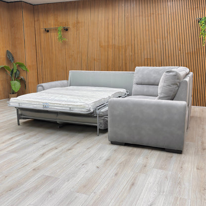 Lifestylle View of the Dove Grey fabric corner sofa transformed into a sofa bed showing the pull-out sleep surface and right-hand facing chaise.