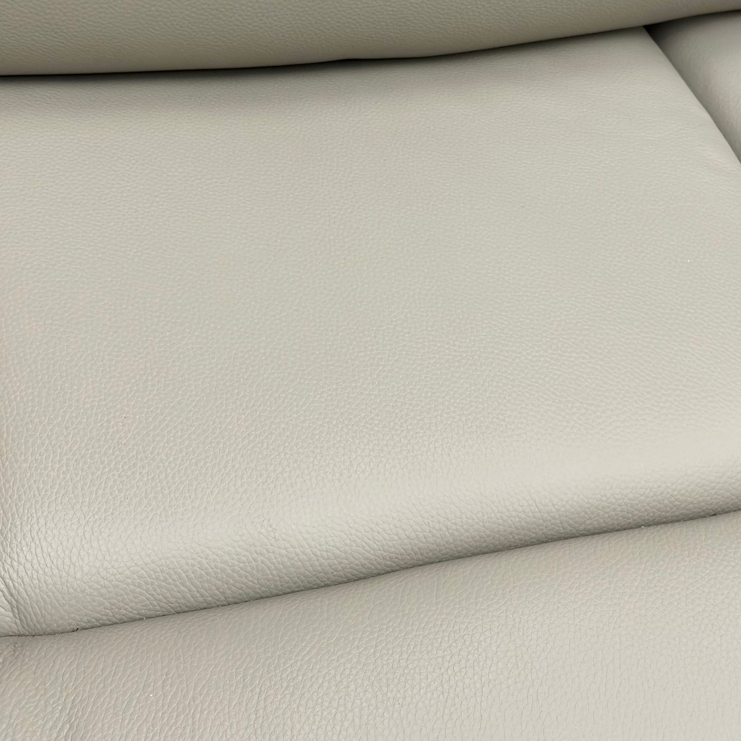 Close-up showing the detail of the Leather texture and stitching on the sofa.