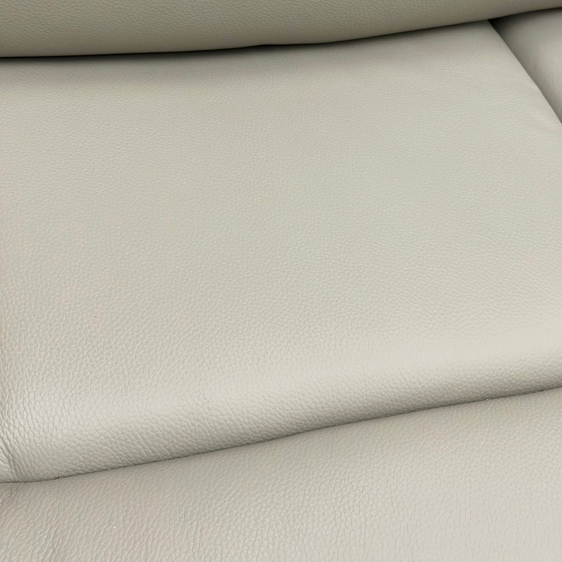 Close-up showing the detail of the Leather texture and stitching on the sofa.