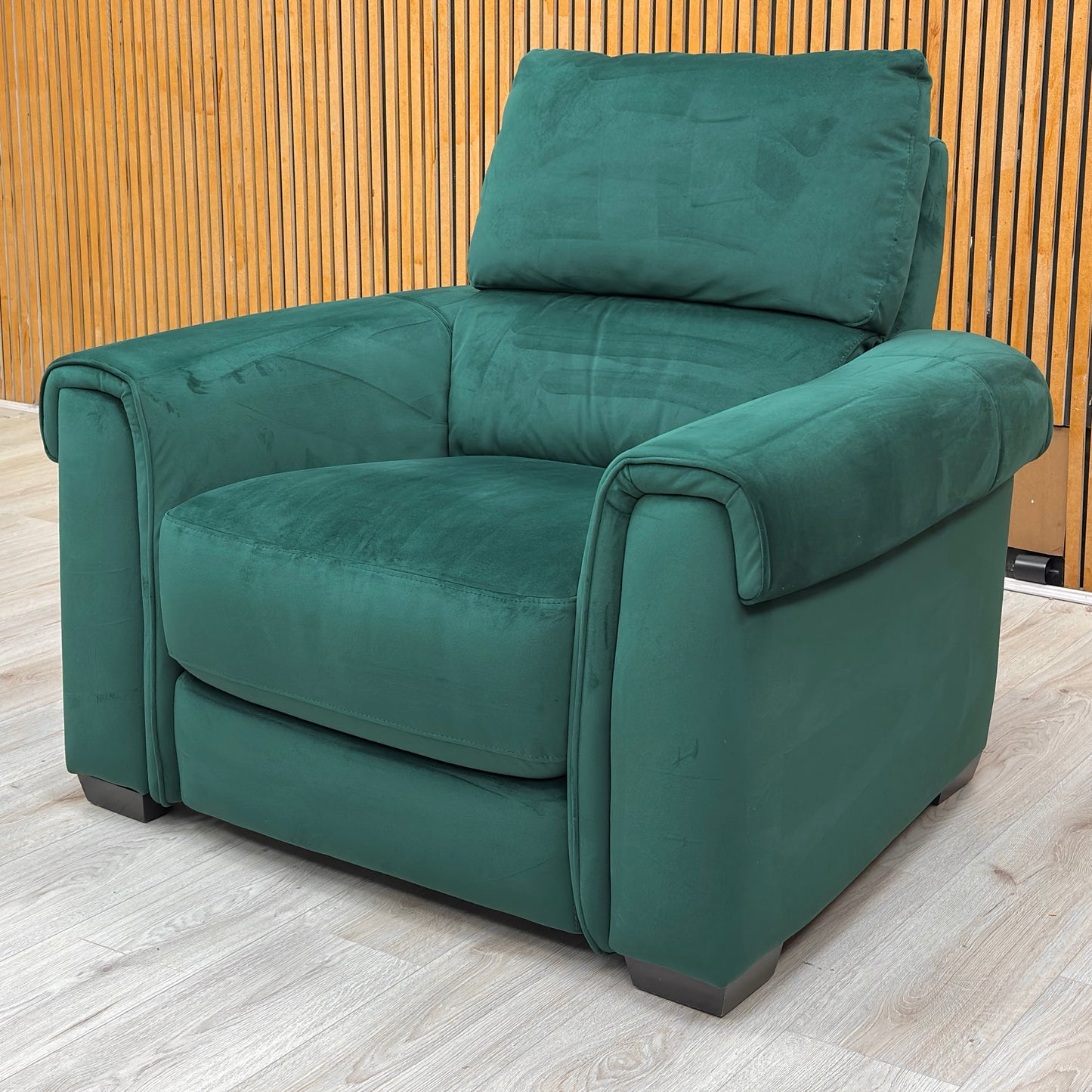 Lifestyle view for the Nixon armchair, highlighting the luxurious Emerald Green velvet upholstery, ergonomic back support, and contemporary silhouette.