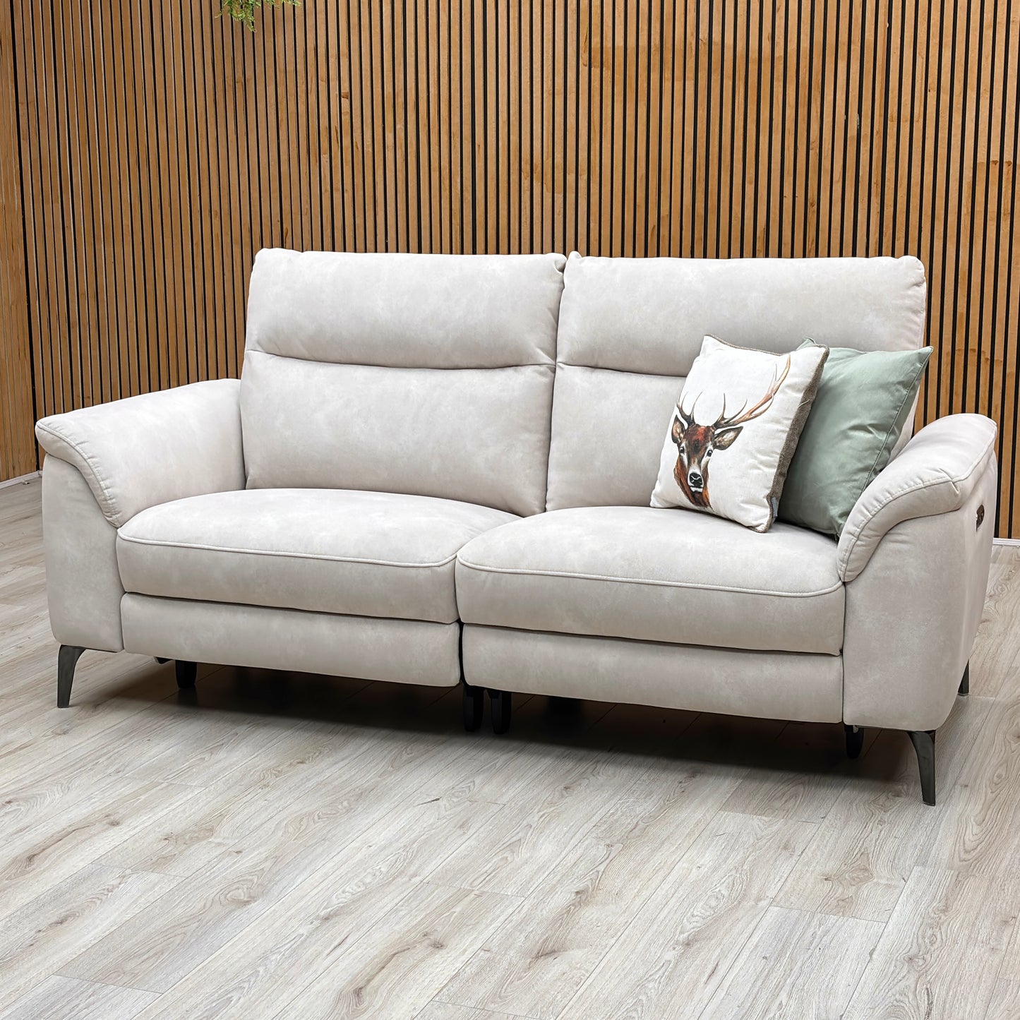 Three-quarter studio perspective with the outer seating sections fully extended, showcasing the raised motorized footrests, relaxed reclining posture, and smooth power transition.