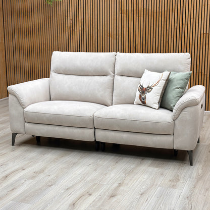 Three-quarter studio perspective with the outer seating sections fully extended, showcasing the raised motorized footrests, relaxed reclining posture, and smooth power transition.