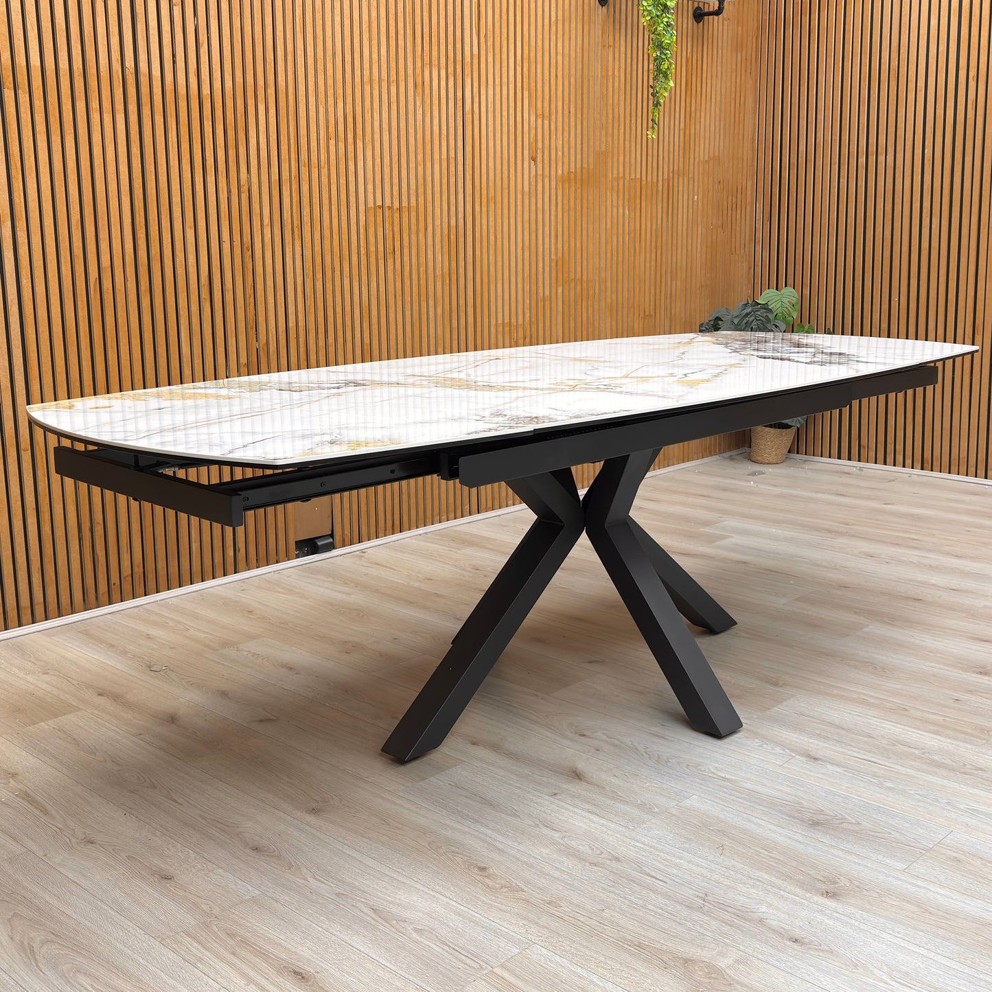 Lifestyle view for the Doro dining table, highlighting the heat, scratch, and stain-resistant ceramic marble surface and the smooth swivel extension mechanism.