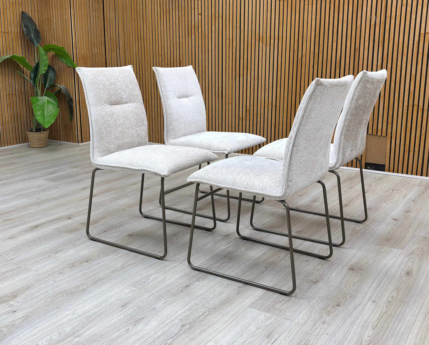 Lifestyle view of the sand Maya chair, highlighting the clean lines of the backrest and the architectural tubular metal frame.