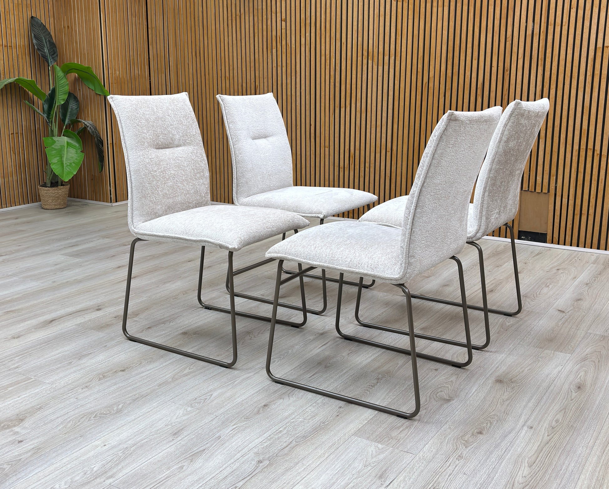Lifestyle view of the sand Maya chair, highlighting the clean lines of the backrest and the architectural tubular metal frame.