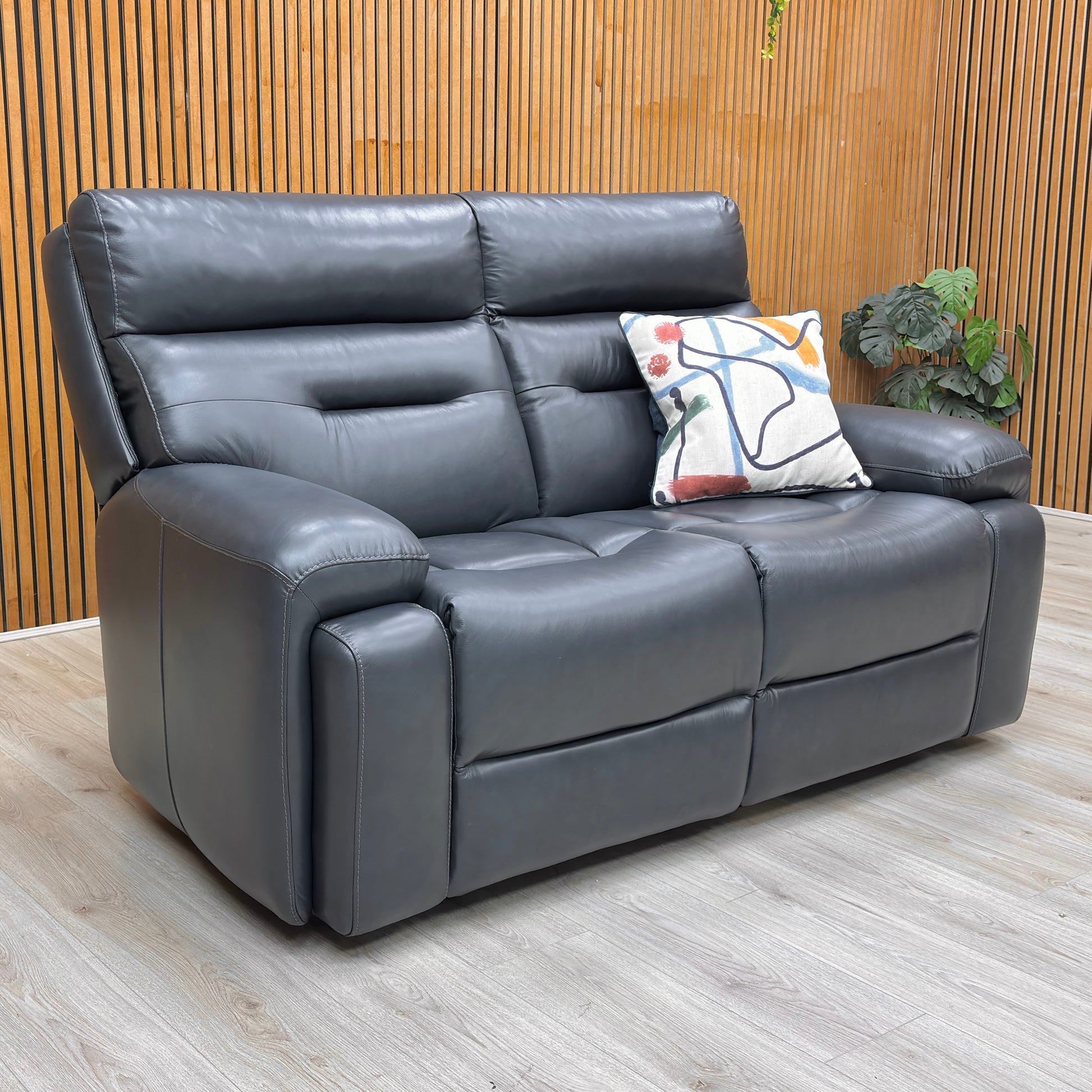 Lifestyle view of the Cinemax 2-seater sofa, highlighting the 100% genuine Navy Blue leather, durable frame construction, and superior lumbar support.