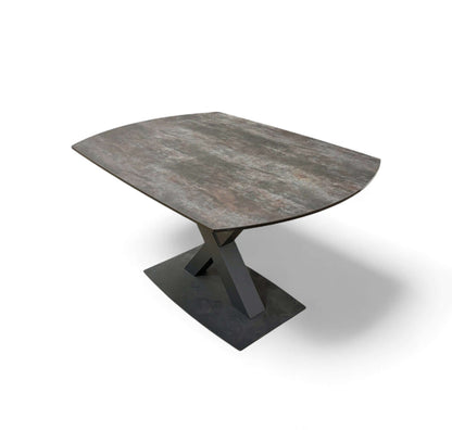 Modern dining table with a textured surface and geometric base on a white background