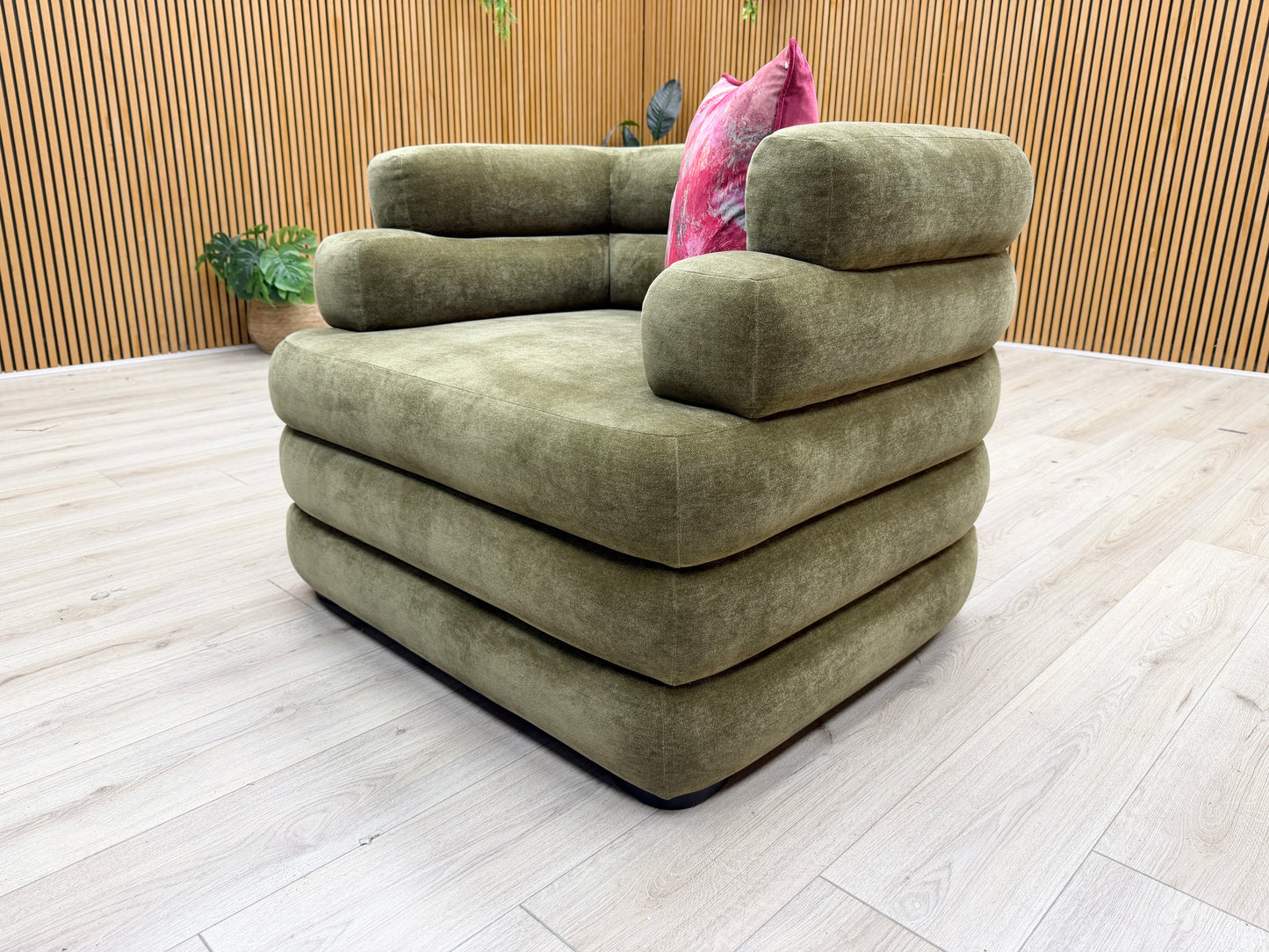 Lifestyle shot of the ‘Stacked’ armchair in a contemporary living room, showcasing its rich olive tone and cozy seating area.
