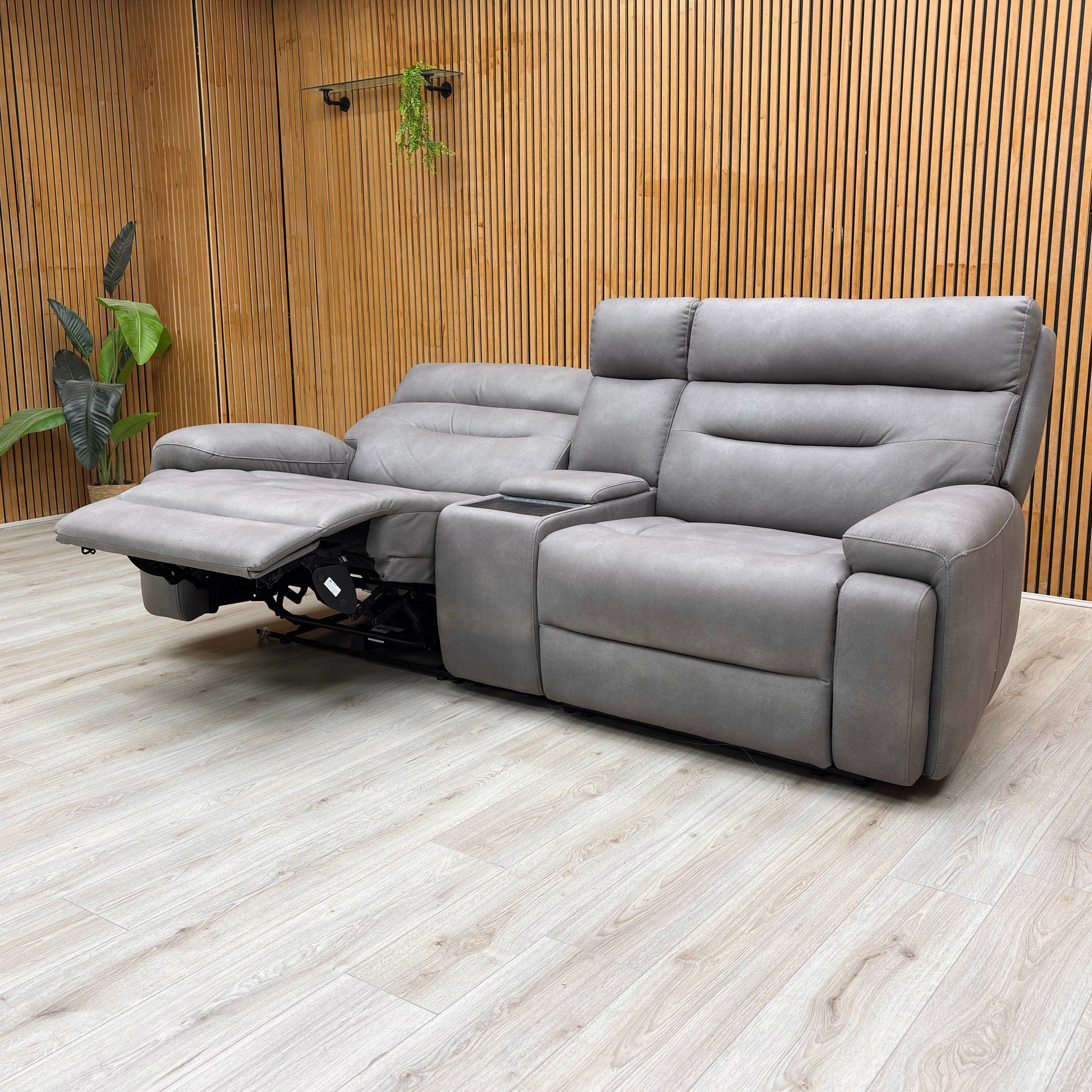 Angled view of the 'Cinemax' Media Sofa with the central backrest folded down, revealing the media tray, cupholders, and control panel.