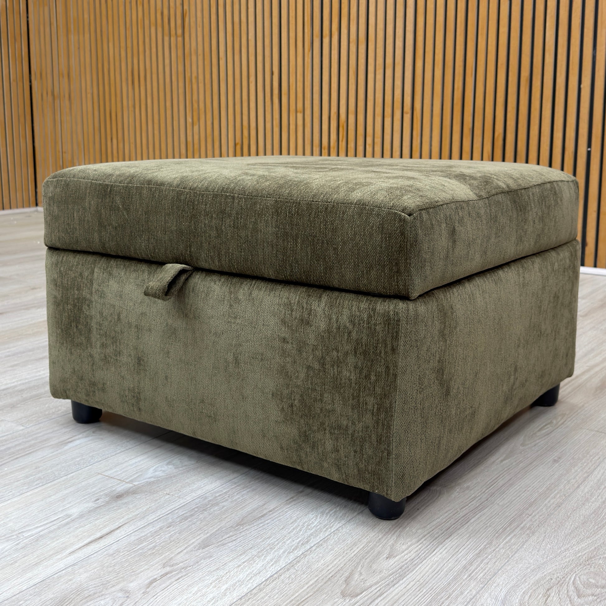 Lifestyle shot of the Harvey storage footstool, highlighting its rich olive green tone and soft weave texture.