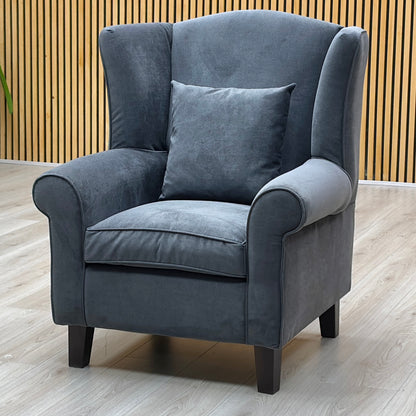 Three-quarter studio perspective highlighting the elegant sweeping profile and full depth of the armchair, emphasizing its plush comfort padding and tailored fabric lines.