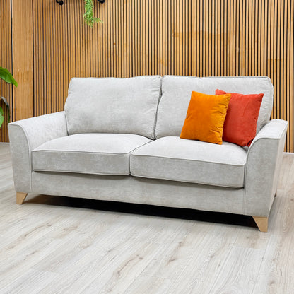 The 3 seater sofa from the Legend Kingston silver fabric set against a slatted wooden wall on a light oak floor