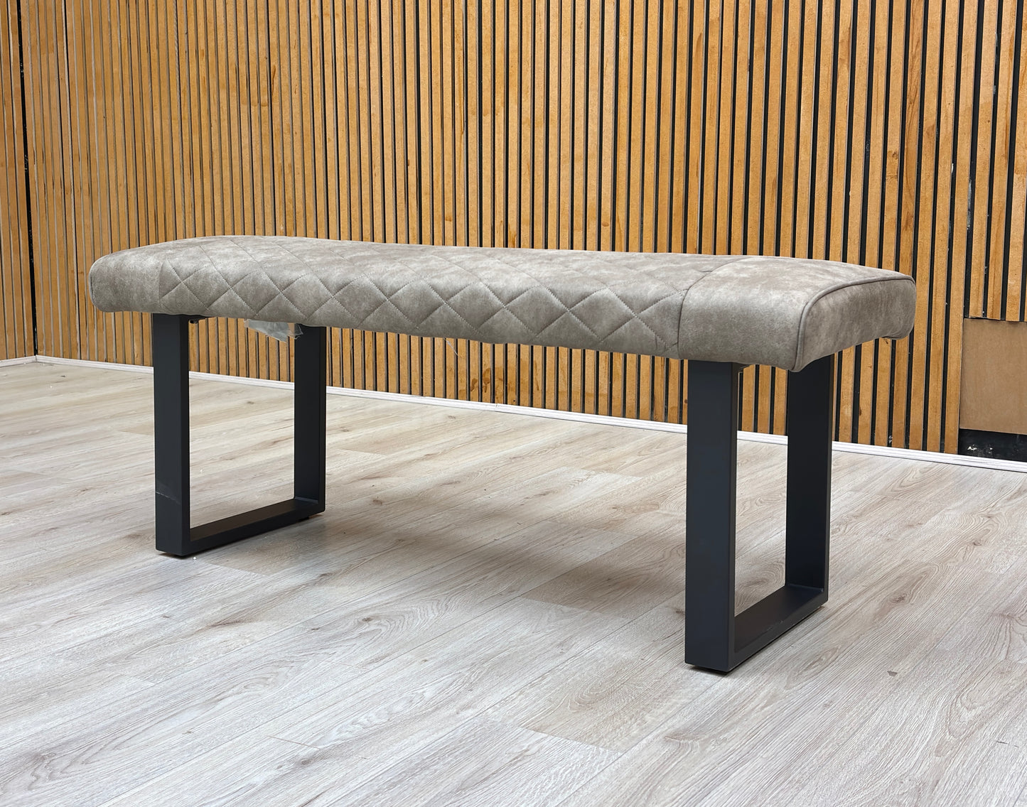 Lifestyle view of Warrior dining bench styled in a modern room setting, showcasing its versatile neutral taupe upholstery.