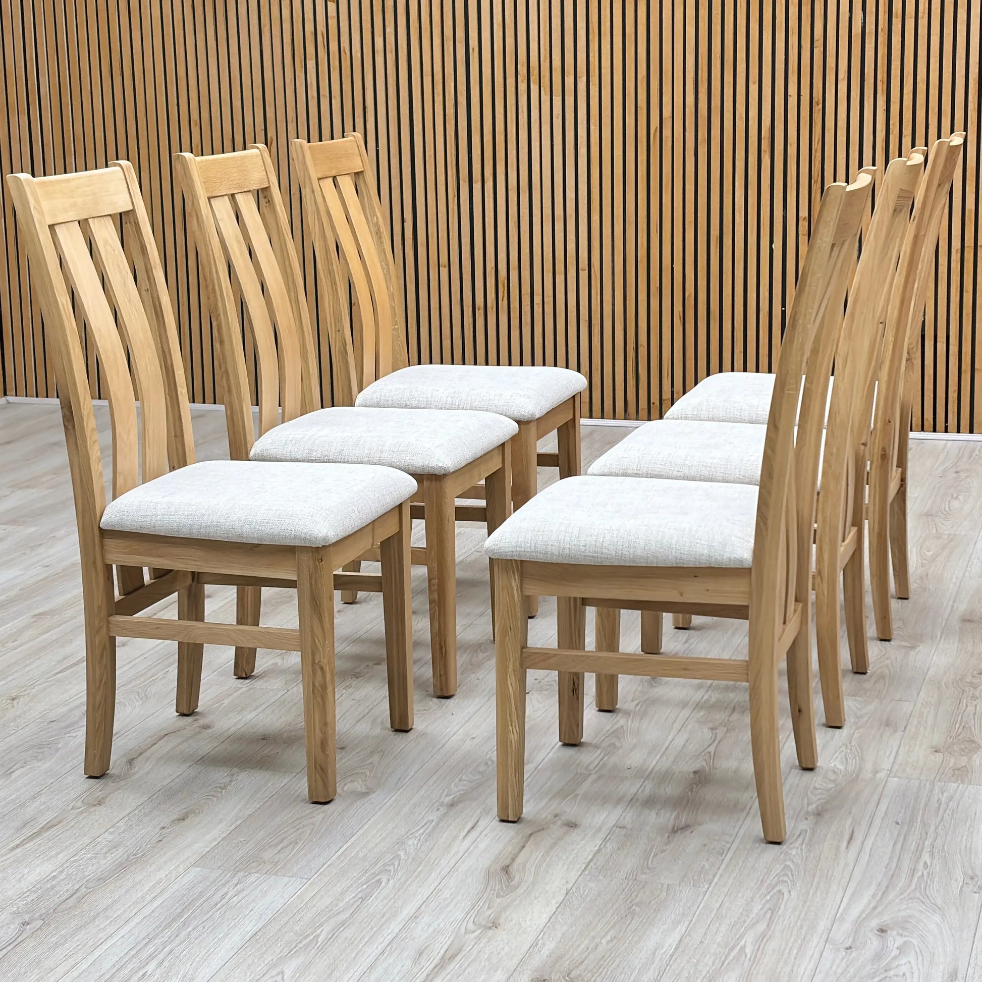 Three-quarter studio view perspective highlighting the classic individual profile, comfortable seating depth, and sophisticated modern-rustic aesthetic of the wooden dining chairs with clay upholstered seats.