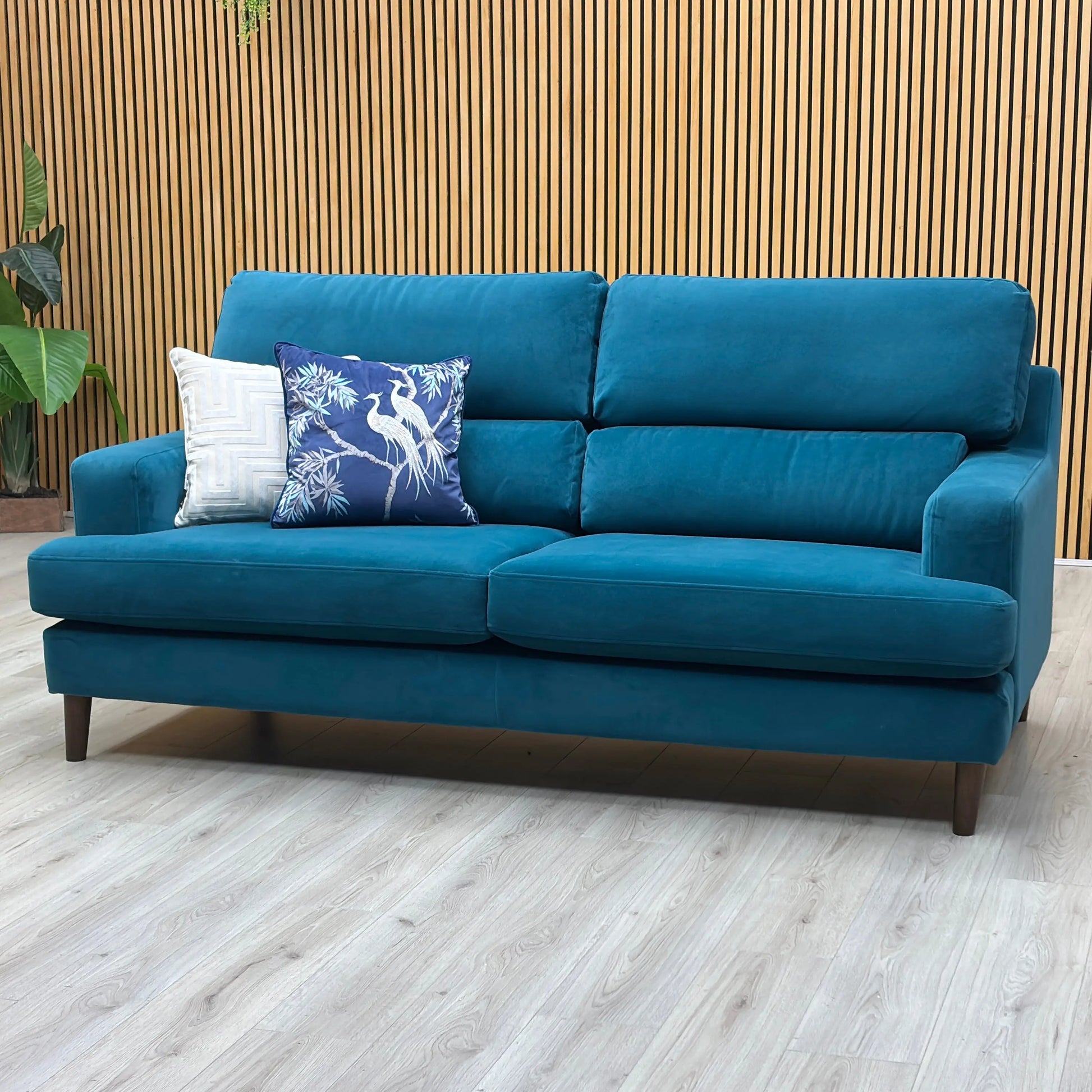 Three-quarter studio perspective highlighting the comfortable deep profile, sleek tailored armrests, and elegant modern silhouette of the dragoneye teal fabric sofa.