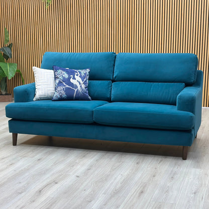 Three-quarter studio perspective highlighting the comfortable deep profile, sleek tailored armrests, and elegant modern silhouette of the dragoneye teal fabric sofa.