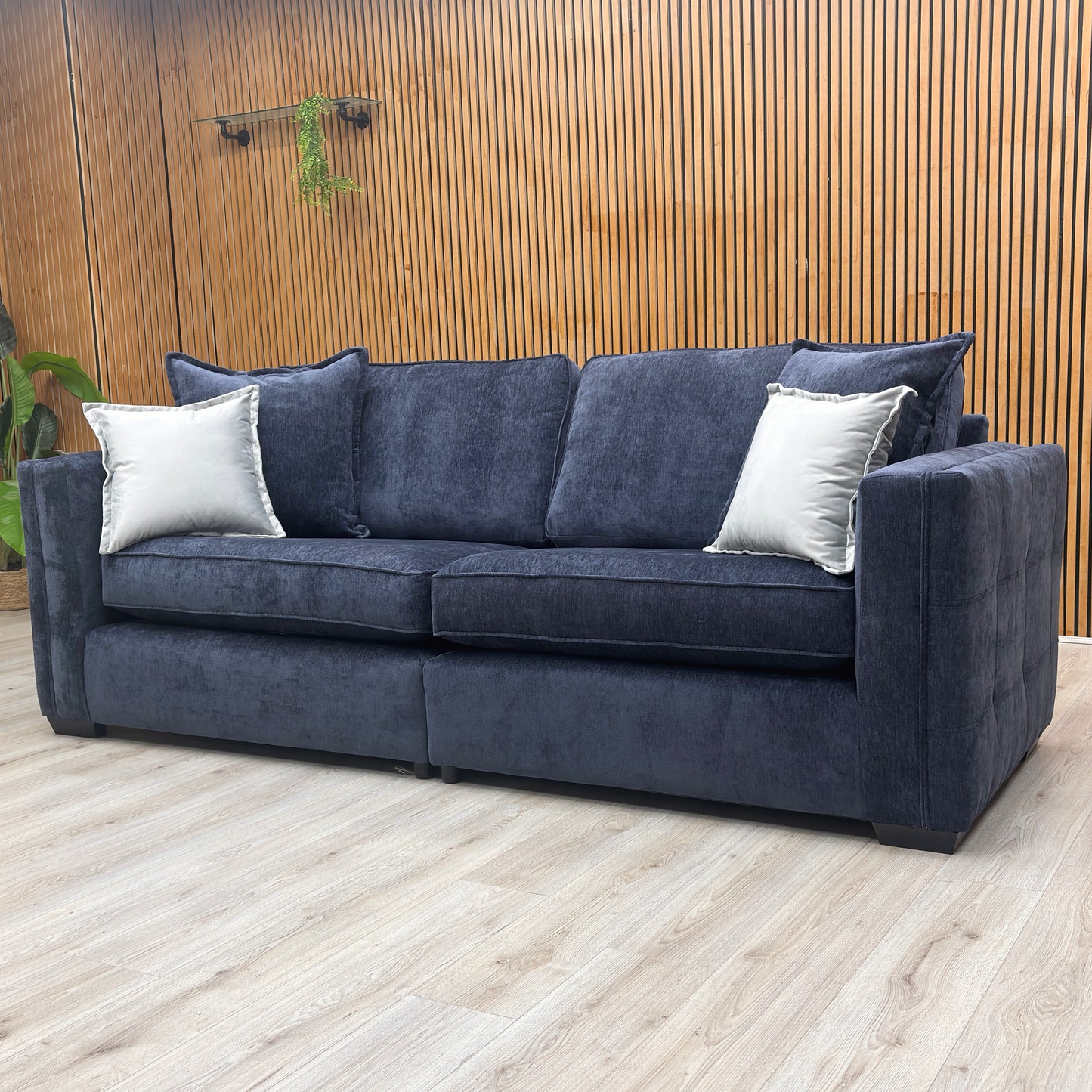 lifestyle image of the large Chelsea 4-seater denim blue sofa in a modern, well-lit living room.