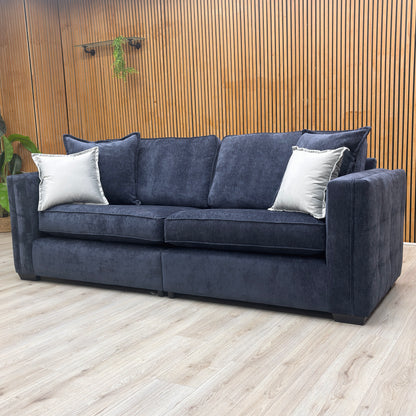 lifestyle image of the large Chelsea 4-seater denim blue sofa in a modern, well-lit living room.
