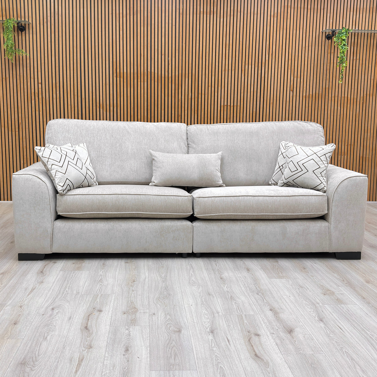 Front view of the Harvey truffle soft weave 4 seater split frame sofa against a slatted wooden wall
