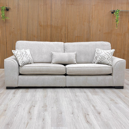 Front view of the Harvey truffle soft weave 4 seater split frame sofa against a slatted wooden wall