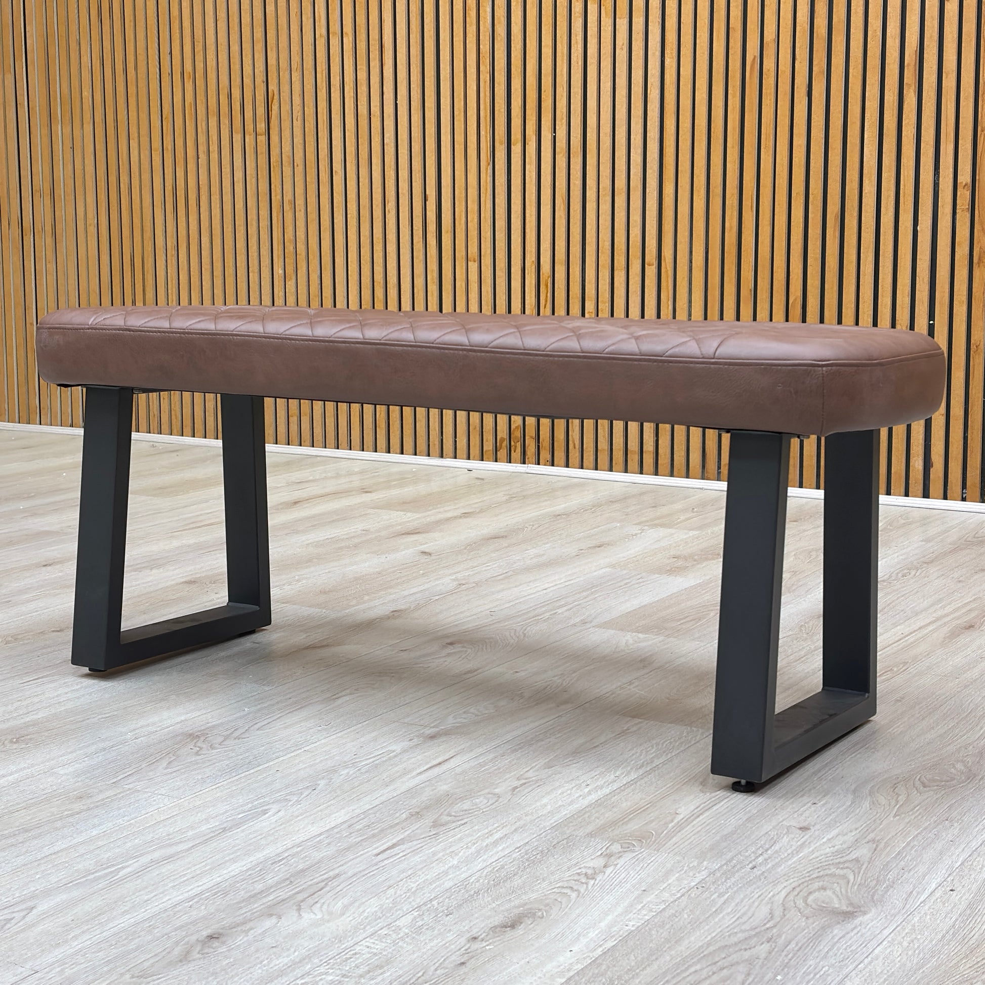 Lifestyle room view of the Venus dining bench showing the stylish diamond-pattern stitching detail on the tan upholstery.