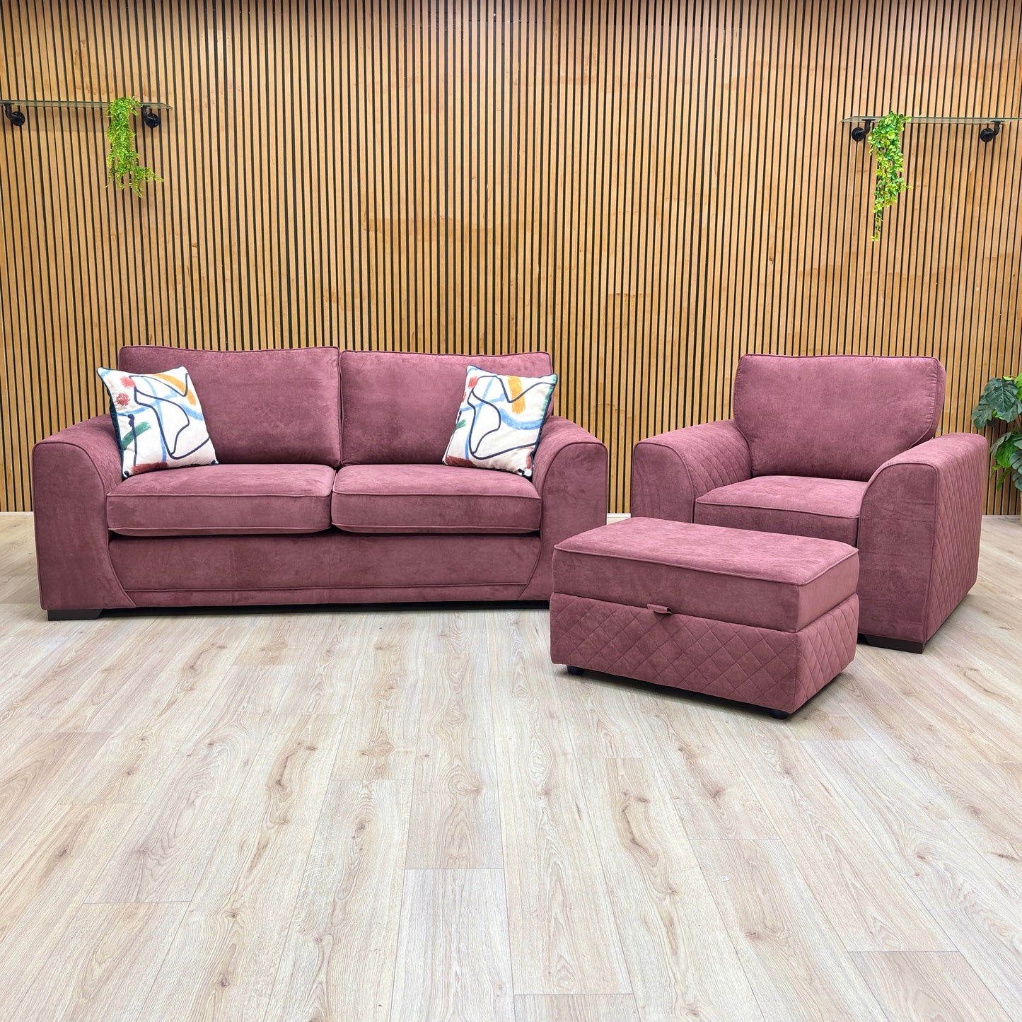 Lifestyle view of the Orka 3 Seater Sofa, Armchair, and Large Storage Footstool in rich Wine Plaza Linen.
