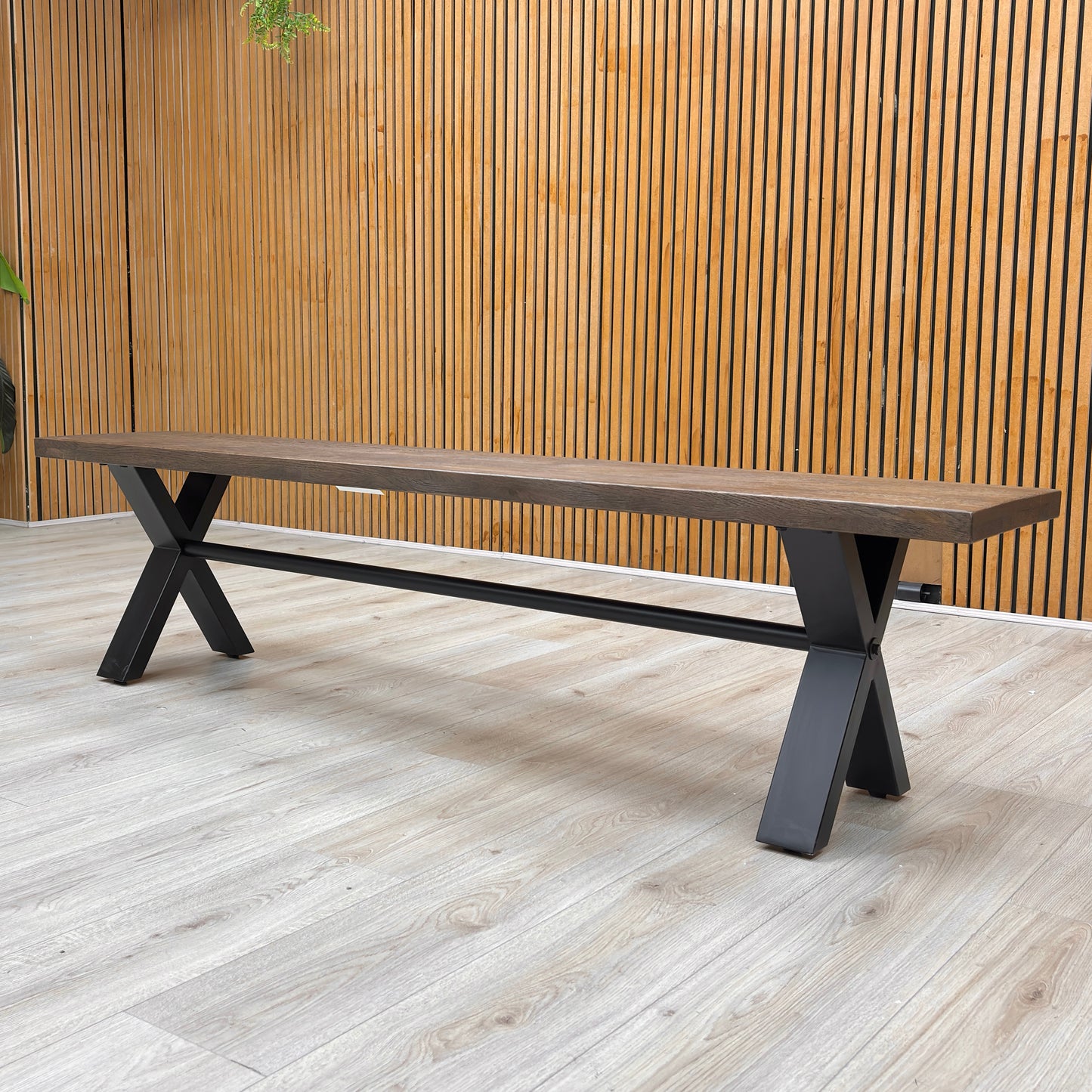A side-angle shot of the bench, highlighting the contrast between the natural dark wood top and the sturdy black metal base.