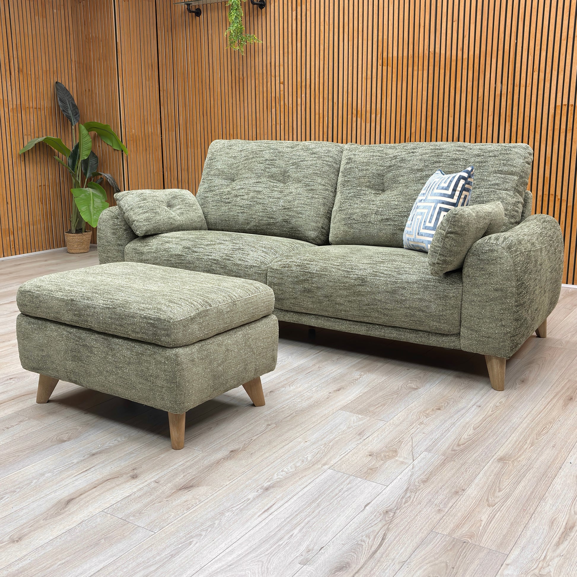 View of the sofa base and legs, highlighting minor scuffs and surface scratches on the black support feet.