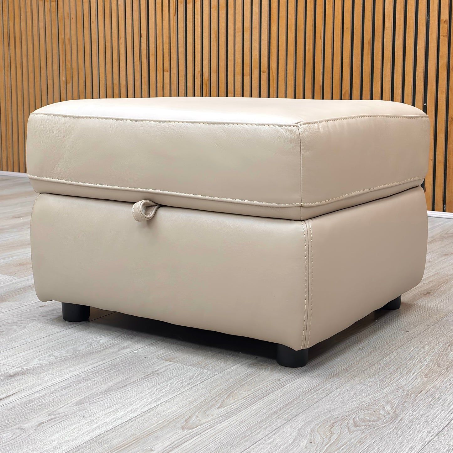Overhead view of the footstool with the storage compartment open, revealing a roomy interior for household items.