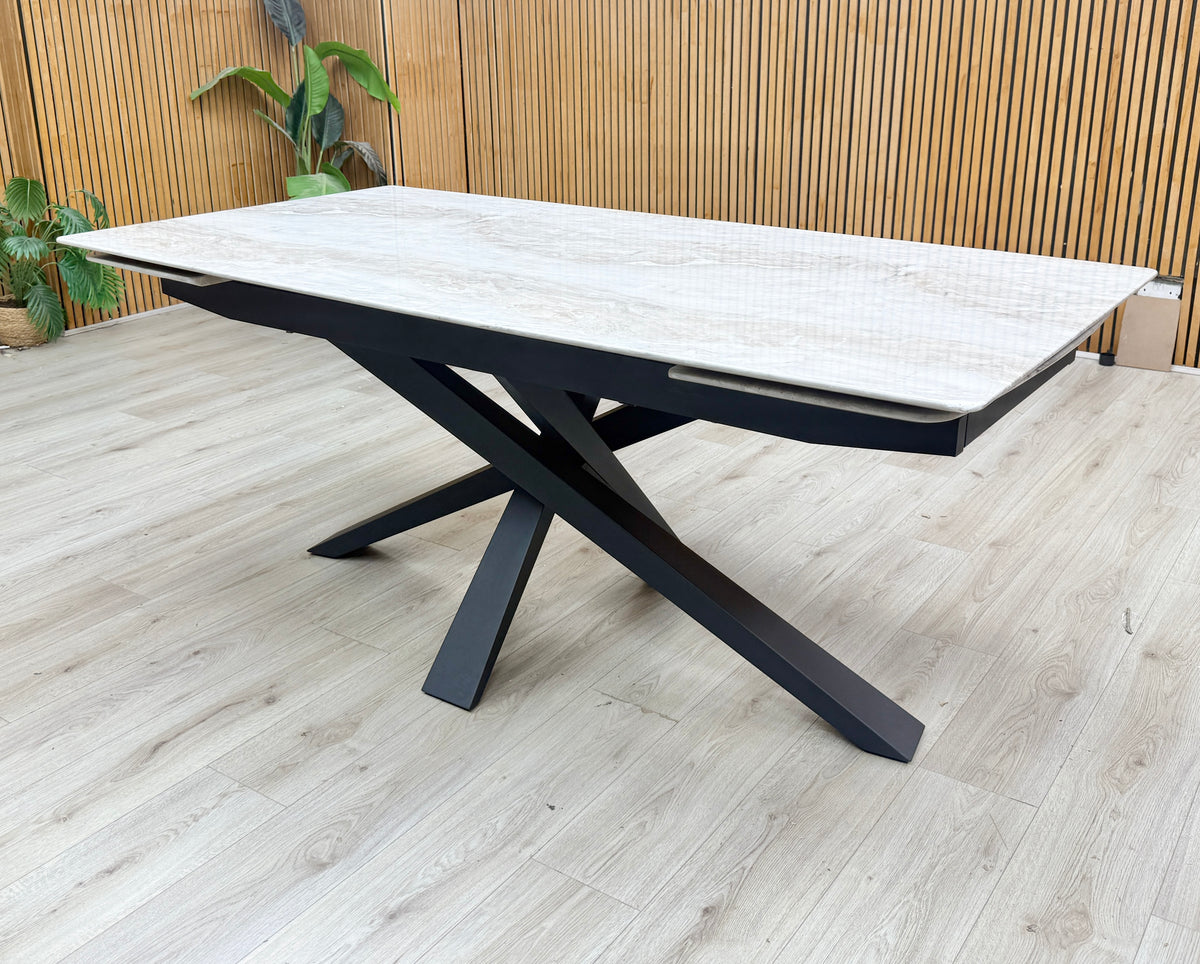 Germain real marble top large extending dining table closed, against a slatted wooden wall on a light wood floor