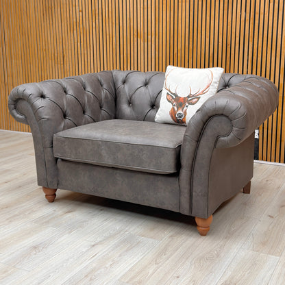Lifestyle shot of the Gosford chair, showcasing the rich texture of the Monza charcoal leather and the sophisticated, traditional silhouette.