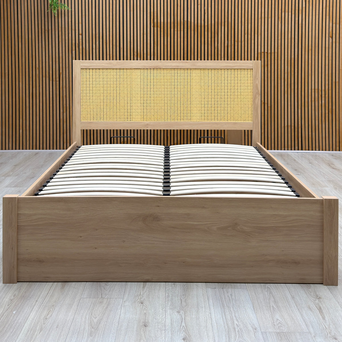 Hamish oak king size end lift ottoman bed on a light oak floor against a slatted wooden wall
