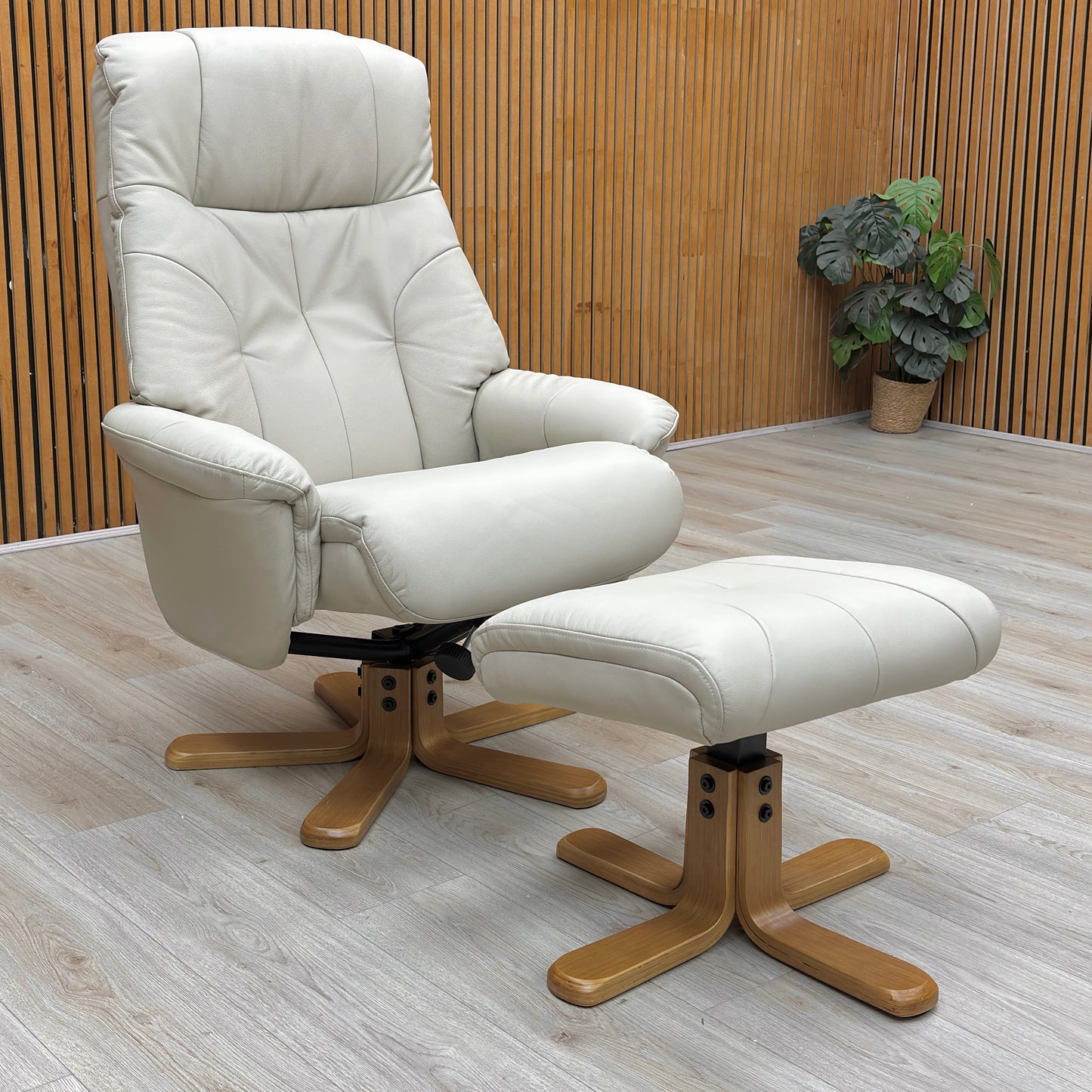 Lifestyle view of the Muscat chair in a reclined position with the footstool, showcasing the soft mushroom leather and plush cushioning.