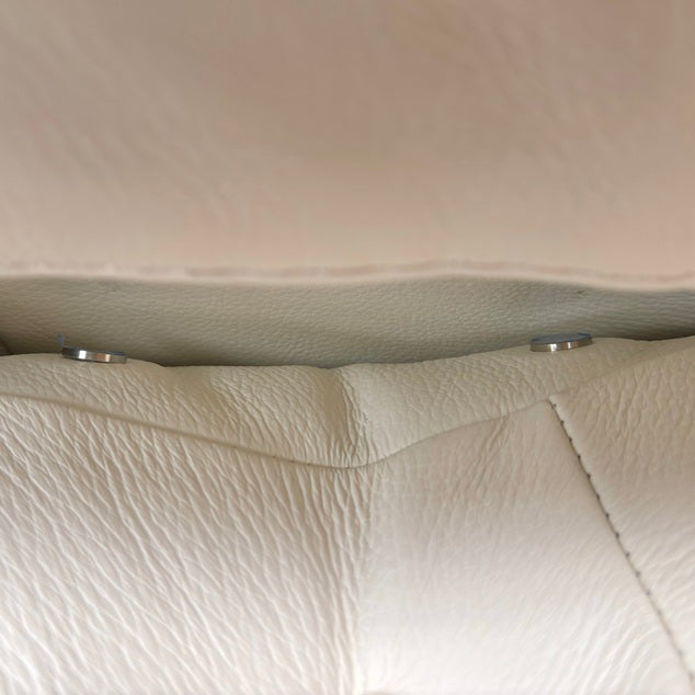 Close-up detail of Bianco Puro 370 premium leather stitching and power controls on Nicoletti recliner. Macro view showcasing the fine Italian leather grain textures, durable tight double-stitching, and intuitive brushed-metal electronic reclining buttons.