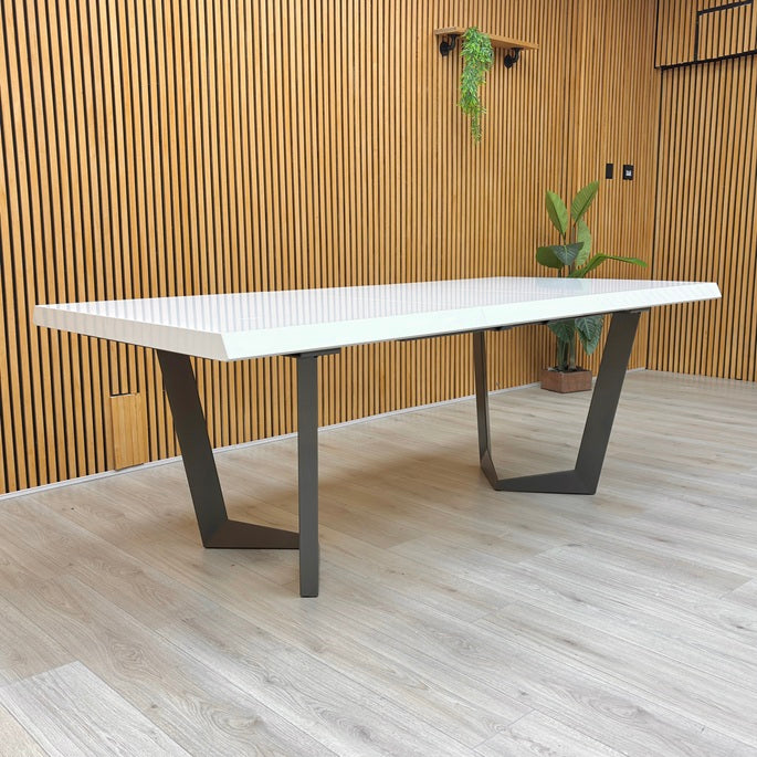 Lifestyle view of the Palazzo table fully extended to 240cm, showcasing the seamless high-gloss surface and spacious seating for 10-12 people.