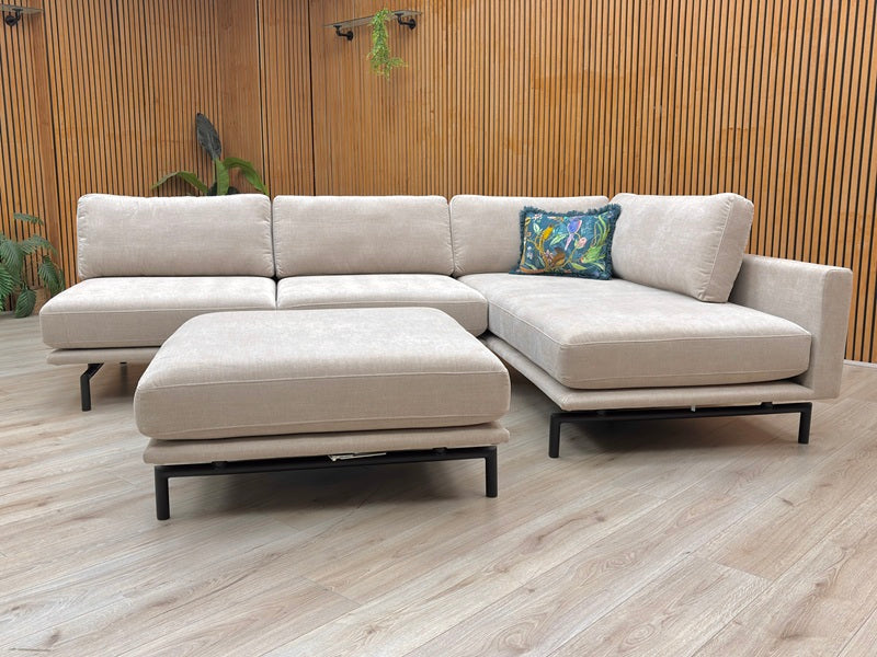 Lifestyle view of the Brixton Taupe Corner Sofa, showing the spacious chaise end and comfortable deep-filled back cushions.