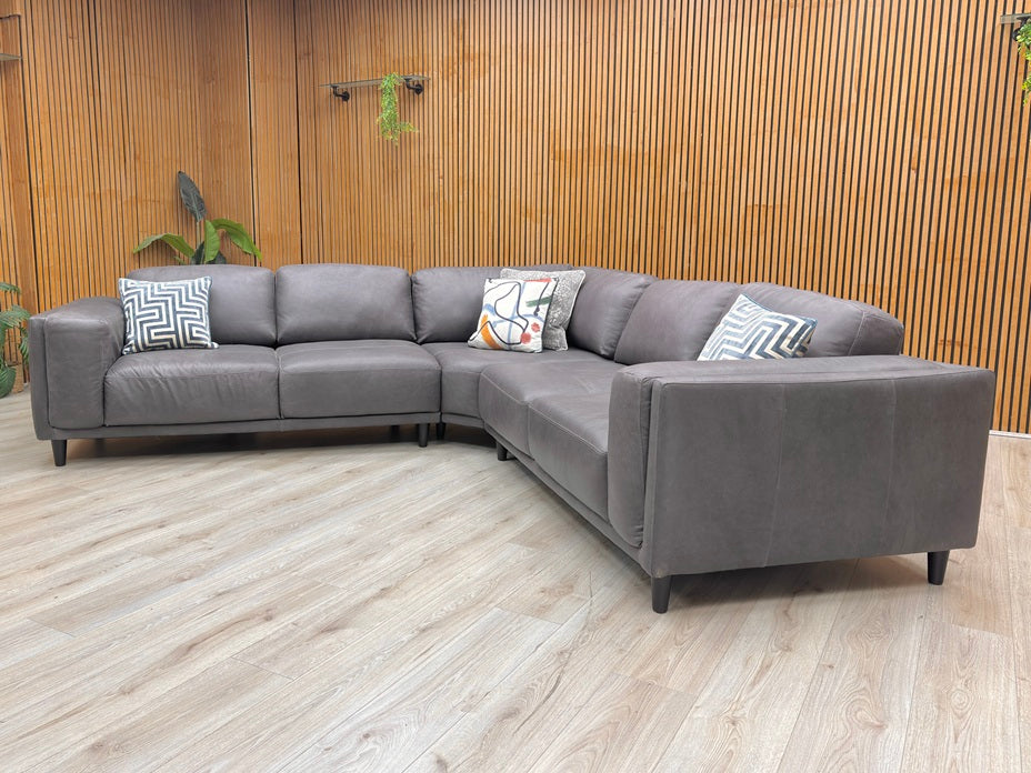 Lifestyle shot of the Brody sofa, highlighting the luxurious sheen of the genuine Italian leather and the clean, structured armrests.