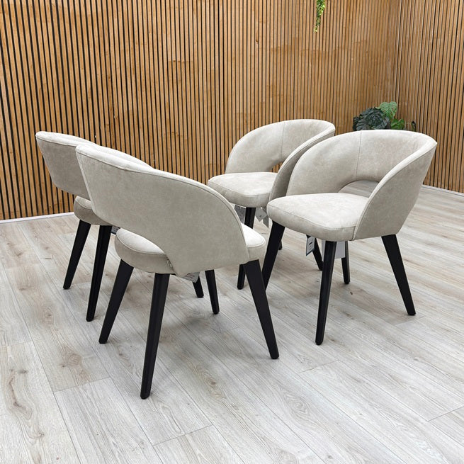 Lifestyle view of a Goya dining chair, showcasing the understated glam style, comfortable low-back silhouette, and dense foam seat cushioning.